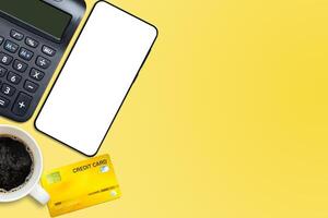 credit card with calculator on vivid yellow background photo