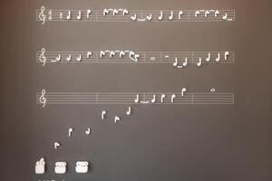 Musical notes and rests arranged on staves, resembling sheet music decor on a plain background. Artistic music notation representation, no Apple Store. photo