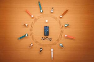 Apple AirTags are perfectly displayed in an eye catching circle on a wooden surface. Symmetric, colorful keychain holders enhance their value. Located near Apple HQ in Mountain View. photo