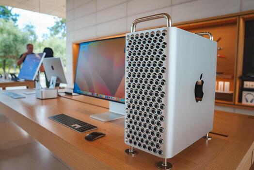 Interior of Apple Store near Apple office complex, Mountain View, CA. Mac Pro with cheese grater design, Apple keyboard, trackpad, and iMac on display. Crowd in background. photo