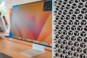 Close up view of Apple product display, featuring iMac with sleek screen and Mac Pro's distinctive circular holes. Location likely Apple Store in Mountain View. photo