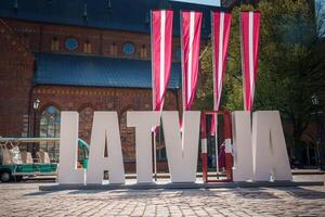 Sunny day in Riga, Latvia with LATVIA letters in front, flag colors. photo
