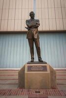 Bronze Statue of Confident John R. Wooden, Suit and Tie Stand, Building Background photo