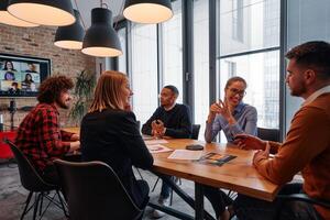In the vibrant ambiance of a modern startup office, a diverse team of business professionals engage in discussions on various projects and develop new business strategies, epitomizing creativity and photo