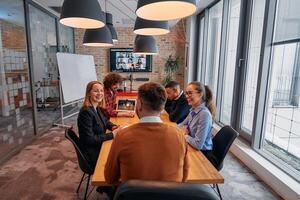 In the vibrant ambiance of a modern startup office, a diverse team of business professionals engage in discussions on various projects and develop new business strategies, epitomizing creativity and photo