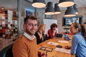 In the vibrant ambiance of a modern startup office, a diverse team of business professionals engage in discussions on various projects and develop new business strategies, epitomizing creativity and photo