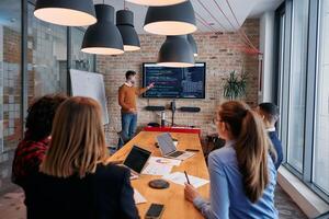 In a corporate setting businessman leads a meeting, passionately presenting a business plan to his attentive team, fostering collaboration and strategic thinking photo