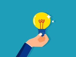 hand holding a light bulb with a star on it vector