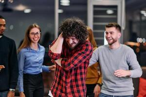 A group of young business people have fun playing interesting games while taking a break from work in a modern office. Selective focus photo