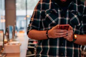 Close Up Young Bearded Programmer Using Smartphone in Office photo