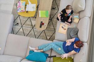 Top View of Mother and Daughter Enjoying a Fun Board Game on the Couch at Home photo