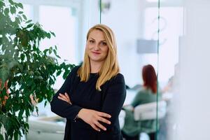 Brunette Businesswoman with Crossed Arms Standing in Front of Modern Office. photo