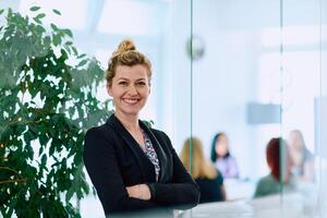 Brunette Businesswoman with Crossed Arms Standing in Front of Modern Office. photo