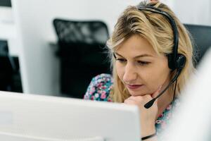 Friendly Call Center Agent Answering Incoming Calls with Headset Providing Remote Customer Service. photo