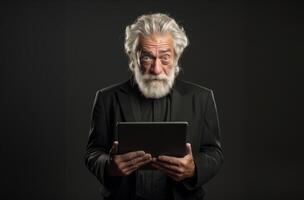 Elderly man with a beard engages with modern technology, using a tablet against a black backdrop, symbolizing the intersection of age and digital connectivity in the contemporary era photo