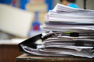 Paper stack on the desk related to business functions. photo