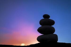 The stones that are stacked together are comparable to yoga meditation. photo