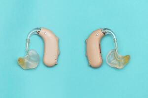 Hearing aid put on Blue background. To live in society. photo