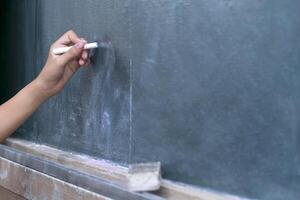 Children are writing on the blackboard with Chalk. photo