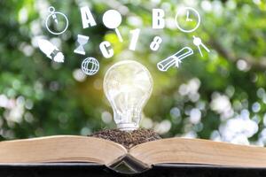 Learning concept, Growing Knowledge, The soil is placed on the book and there is a light bulb located, drawing with set of education icons. photo