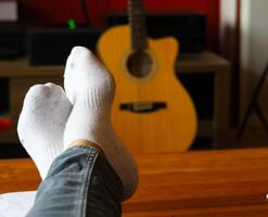 person relaxing at home with guitar in the background photo