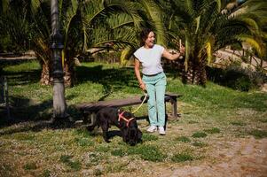 Woman taking a selfie with her dog in a sunny park on a beautiful day photo
