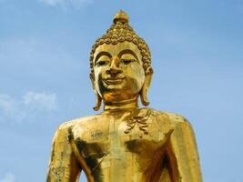 Big golden Buddha statue on a bright sky background - Landmark Famous sculpture statue in Thailand Temple. photo