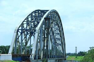 Railway tracks on a sturdy steel bridge visible on a beautiful day photo