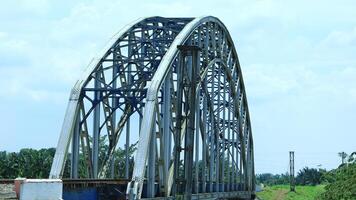Railway tracks on a sturdy steel bridge visible on a beautiful day photo