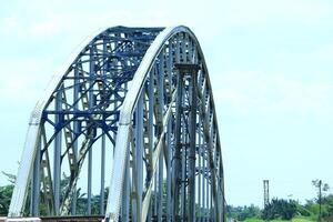 Railway tracks on a sturdy steel bridge visible on a beautiful day photo