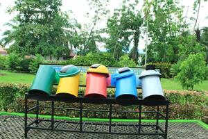 Organic and non-organic waste bins are neatly arranged in a park photo