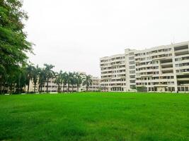 Landscape View of big trees and buildings next to green playground photo