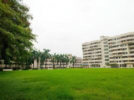 Landscape View of big trees and buildings next to green playground photo