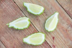 Fresh bergamot or sliced kaffir lime fruit with isolated on traditional wooden table photo
