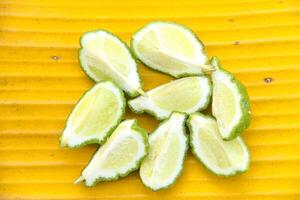 Fresh bergamot or sliced kaffir lime fruit with isolated on yellow color background photo