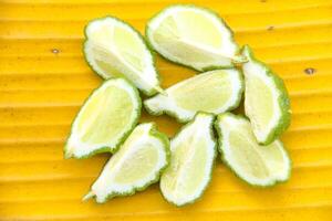 Fresh bergamot or sliced kaffir lime fruit with isolated on yellow color background photo