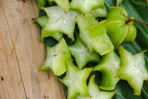 Carambola fruit with slice of star fruit on a wooden table photo