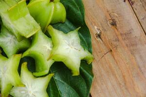 Carambola fruit with slice of star fruit on a wooden table photo