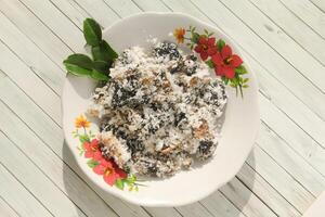 Gatot food with grated coconut topping, Gatot is a typical Indonesian food made from cassava which is dried for some time to produce a distinctive black color photo
