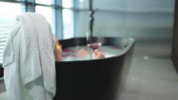 Spa relaxation. Woman lying in bath with holding glass with red wine. Girl relaxing in bathroom at home. Pretty female taking hot bath drinking wine. Stress relief. Rest after hard working day video