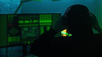 Hacker is sitting alone, engaging in wiretapping and spying on people using a computer. Medium shot. Slow motion. video
