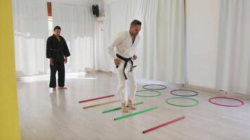 Two Men Train With Jumping Obstacle Exercises During Karate Training video