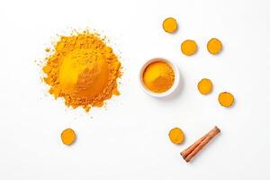 Turmeric Powder and Root Slices with Cinnamon Stick on White Background photo