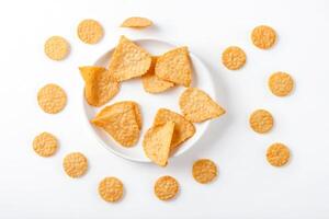 Crispy Rice Crackers in a Bowl with Scattered Crackers on a White Background photo