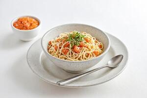 Close-up of a bowl of spaghetti with tomato sauce and basil photo