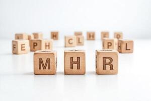 Wooden blocks spelling MHR on a white background photo