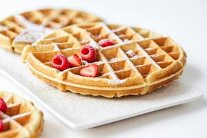 Close Up of Fresh Waffles with Berries and Powdered Sugar photo
