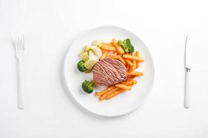 Steak with Vegetables and Fries on White Background photo