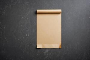 Blank Brown Paper Roll on Black Textured Background photo
