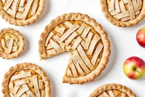 Homemade apple pies with a lattice crust and apples on white background photo